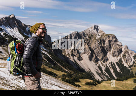 Autriche, Tyrol, smiling young man en randonnée dans les montagnes Banque D'Images