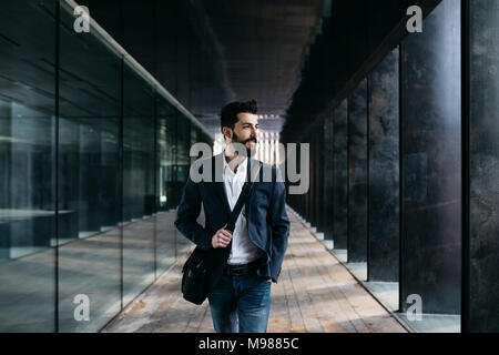 Businessman walking le long d'arcade Banque D'Images