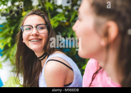 Teenage girl with braces et verres à la recherche à l'ami Banque D'Images