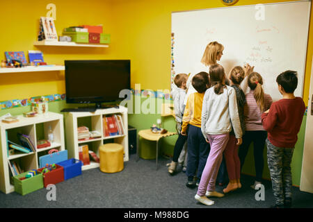 Avec les élèves de l'enseignant écrit sur le tableau blanc Banque D'Images