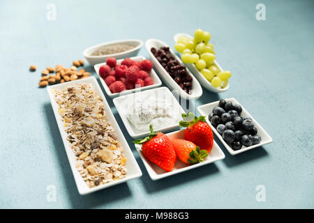 Ingrédients de muesli, graines de chia, fromage, raisins, canneberges, bleuets, framboises, fraises, amandes Banque D'Images