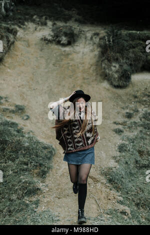 Fashionable young woman wearing hat et descente en poncho Banque D'Images