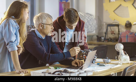 En Informatique Professeur examine Robot programmé par fille et garçon. Banque D'Images