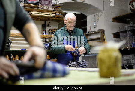 Cordonnier senior travaillant sur chaussons en atelier Banque D'Images