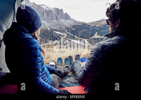 Couple sitting in tente dans les montagnes à la vue à Banque D'Images