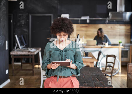 Young woman using tablet in modern office Banque D'Images