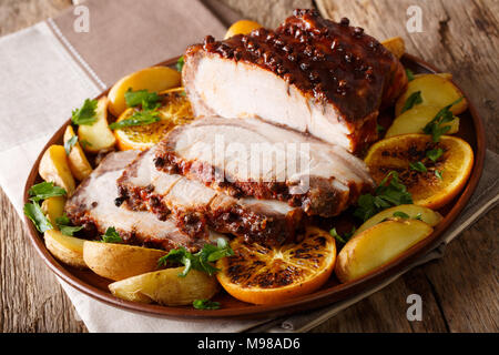 Jambon cuit de Noël avec des pommes de terre tranches hachées, les oranges et les pommes sur une assiette. L'horizontale Banque D'Images