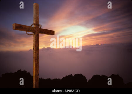 La croix de Jésus Christ vide accueille le lever du soleil de Pâques. Banque D'Images