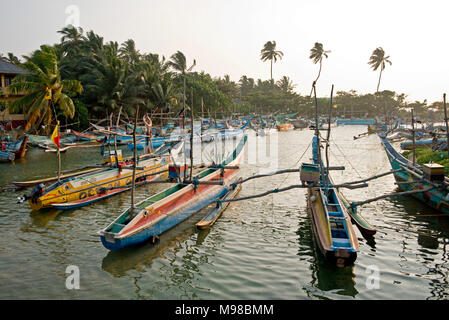 Port de pêche de Dodanduwa - un petit village de pêcheurs près de Kandy au Sri Lanka avec des bateaux de pêche traditionnels et prises contre jour. Banque D'Images