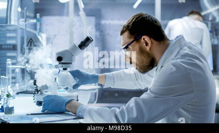 Dans un laboratoire de recherches chimiques mélanges composés de scientifiques fumeurs béchers. Banque D'Images