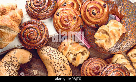 Pains, brioches, croissants. Les ingrédients de boulangerie sur fond de bois. Petit déjeuner d'un concept. Vue d'en haut Banque D'Images