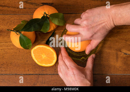 Faire un jus d'oranges sur une table en bois Banque D'Images