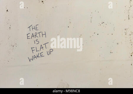 Urbaine profonde graffiti griffonné sur Plymouth philosophique mur - La Terre est plate (peut-être métaphore de Flat Earth Society. Les croyances personnelles. Banque D'Images