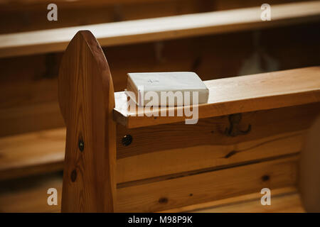 Sainte Bible dans un livre blanc sur un banc en bois à l'église. Banque D'Images
