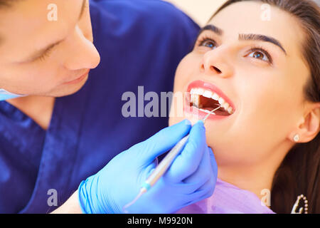 Le dentiste l'homme sont le traitement de dents pour client en cabinet dentaire. Banque D'Images