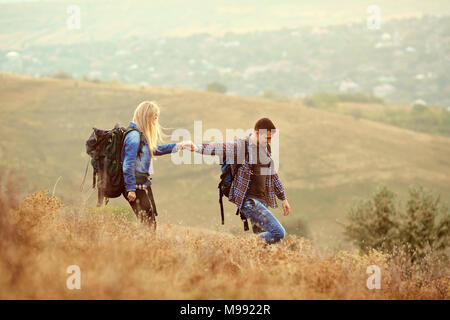 Un jeune couple de touristes avec des sacs à dos sont la marche dans la nature. Banque D'Images