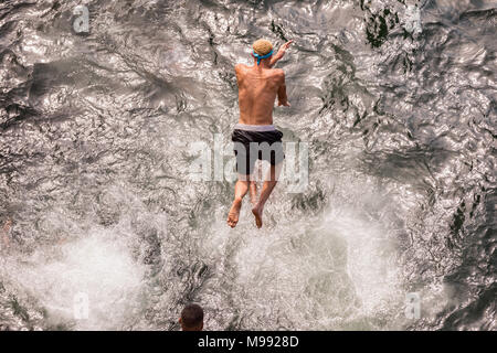 Les garçons de La Havane sont largués de l'des rochers dans la mer. Cuba, La Havane. Rassembler des jeunes Cubains sautant de rocher sur la mer. Banque D'Images