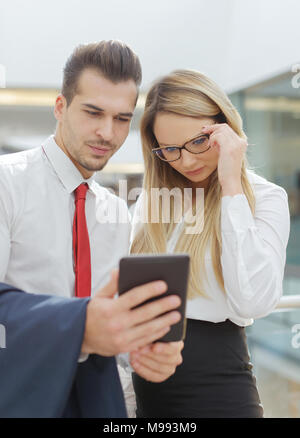 Caucasian businessman and businesswoman reading mauvaises nouvelles sur tablette numérique, la technologie sans fil Banque D'Images