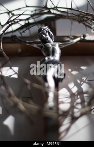 Couronne d'épines et crucifix dans l'éclairage dramatique. Banque D'Images