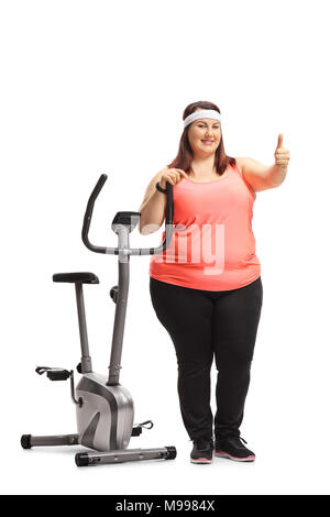 Portrait d'un embonpoint woman leaning on d'un vélo et de faire un pouce vers le haut signe isolé sur fond blanc Banque D'Images