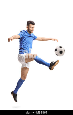 Soccer player jumping and kicking football un isolé sur fond blanc Banque D'Images