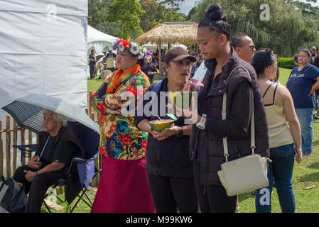 Un groupe de personnes à Pasifica Festiva ; Auckland. Certaines femmes mangent de la moitié melons utilisés comme des plaques. Banque D'Images