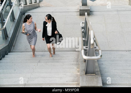 Deux femmes d'Asie en parlant de partager leurs avis avec les autres. Il vient de terminer une conférence. Ils vont à la gare pour retourner à la t Banque D'Images