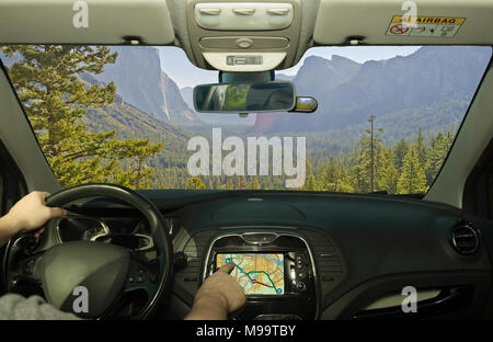 La conduite d'une voiture tout en utilisant l'écran tactile d'un système de navigation GPS vers un endroit vert dans la vallée de Yosemite National Park, États-Unis Banque D'Images