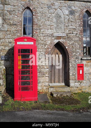 Téléphone public britannique rouge traditionnelle boîte contenant une unité de défibrillateur, Dartmoor Banque D'Images