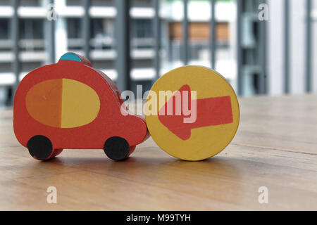 Voitures jouet en bois avec la flèche sur le cercle sur la table. Banque D'Images