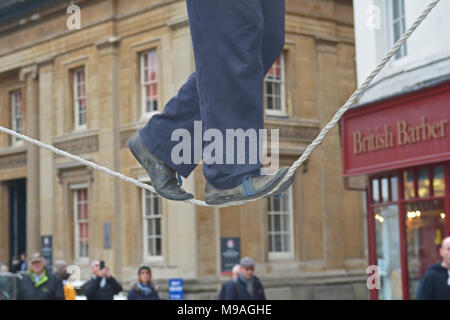 Bristol, Royaume-Uni. Le 24 mars 2018. Un après-midi d'animations de rues dans le vin Street, Bristol. Une performance de Slackline entre deux post par personne par la lecture d'un violon et d'équilibrage habilement en marchant sur une corde suspendue dans middair et regardé par les spectateurs .Robert Timoney/Alamy/live/News Banque D'Images