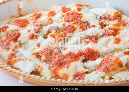 Cannellonis farcis maison (cannelloni di magro) aux épinards et ricotta couverte de sauce tomate, béchamel et fromage grana. La cuisine Italienne Banque D'Images
