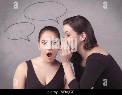 Deux jeunes filles discuter et partager leurs secrets avec concept appelée chat bulles sur le background urban mur. Banque D'Images