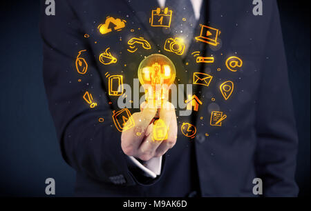 Un bureau commercial promouvoir ses idées de concept avec l'illustration des médias en ligne et les logos de l'appareil autour de l'ampoule en verre électrique. Banque D'Images