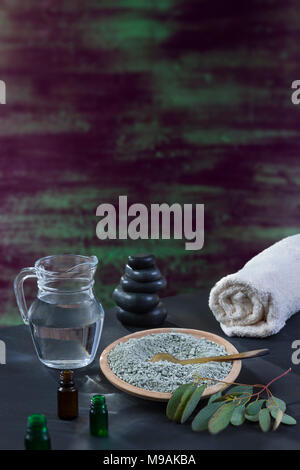 Beaty et Spa concept : mortier en verre avec feuille d'eucaliptus, essentiel oin, serviette blanche cupp d'argile sur une épaisseur de pinceau avec de la peinture dans les tons de vert, bleu, violet texture bois Banque D'Images