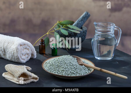 Composition Spa sur fond de bois noir blanc serviettes roulées. gant de gommage, gant, pluie, eucalyptus , argile verte, masque pour le visage et le corps, Banque D'Images