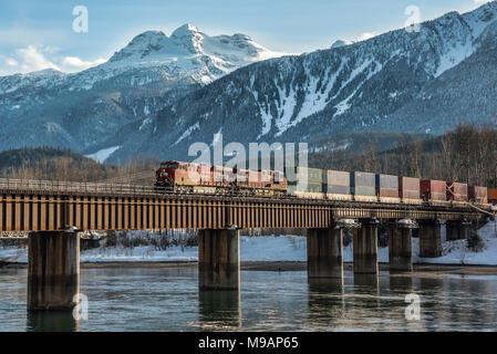 Le CFCP loco 9351 train intermodal conduit en hiver sur le pont de la rivière Columbia avant Mt Begbie à Revelstoke BC  Banque D'Images