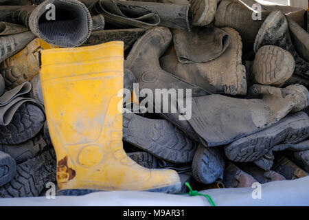 Bottes de gomme utilisée accumulée empilés dans l'extérieur de rack Banque D'Images