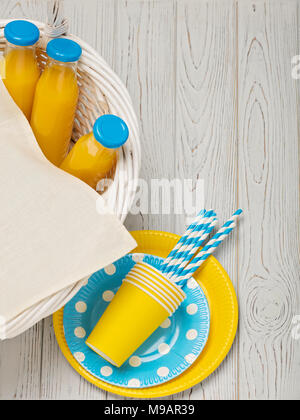 Pique-nique d'été. - Pique-nique sucré le jus d'orange et jaune et bleu plats jetables. Vue d'en haut. Banque D'Images