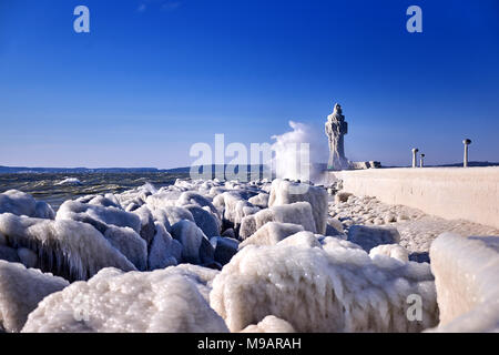 Phare congelé et pier sur journée d'hiver orageux Banque D'Images