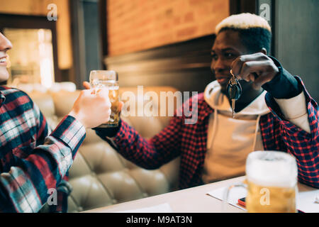 Homme jeune est holding car keys et refusant de boire de la bière de son ami dans un pub. Ne pas boire et conduire. Banque D'Images