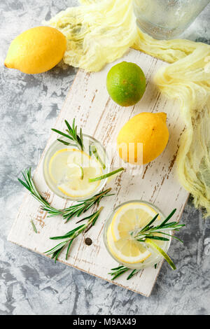 Boisson alcoolisée avec citron et rosemain, dans les verres sur une table lumineuse. Vue d'en haut Banque D'Images