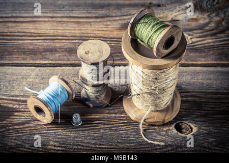 Les aiguilles et les threads en atelier sur mesure sur fond de bois Banque D'Images