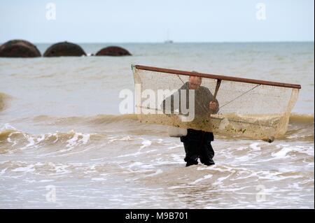 Les hommes la capture de crevettes, crevettes, crabes et autres fruits de mer dans le surf sur la plage de Sovereign Harbour Eastbourne Banque D'Images