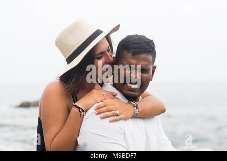 Belle femme caucasienne hugs son mari et mord l'oreille un peu. Concept de l'amour vrai et moments drôles dans la vie de famille Banque D'Images