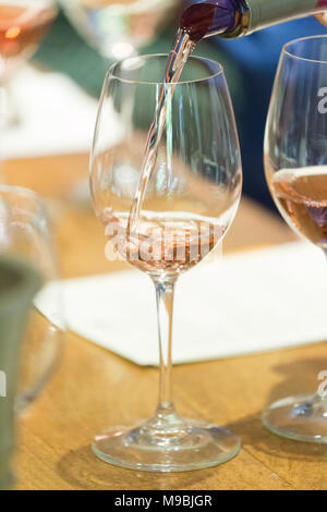 Vin rose est versé dans un verre au cours d'une dégustation de vin Banque D'Images