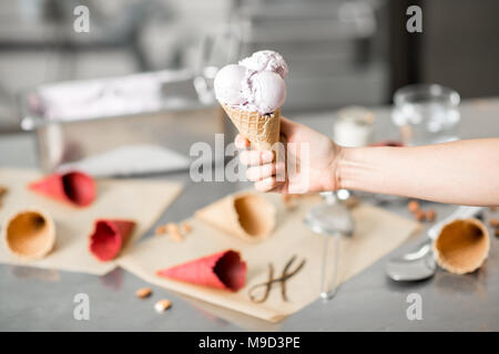 Holding cornet gaufré avec de la crème glacée à l'intérieur Banque D'Images