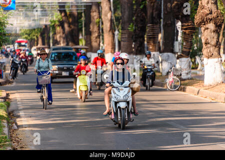 Les scooters, vélos et conduire des voitures le long d'une route dans la région de Siem Reap, au Cambodge. Banque D'Images