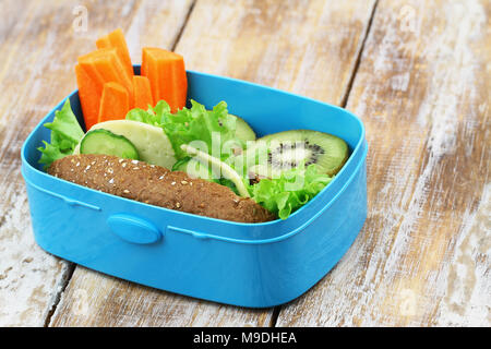 École en santé le déjeuner composé de fromage brun rouleau, carottes fraîches et kiwis Banque D'Images