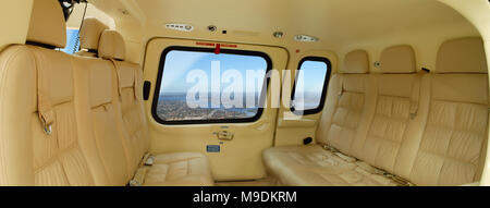 Panorama de l'intérieur d'un hélicoptère Agusta 109 avec sièges en cuir crème. Vide intérieur avec une vue montrant l'hauteur visible par windows. Banque D'Images